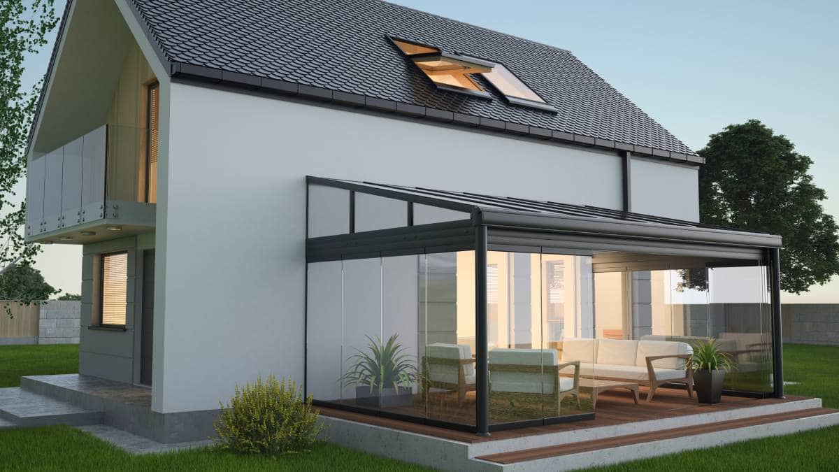 Een terrasoverkapping met schuifbare glazen wanden tegen een veranda of woning.