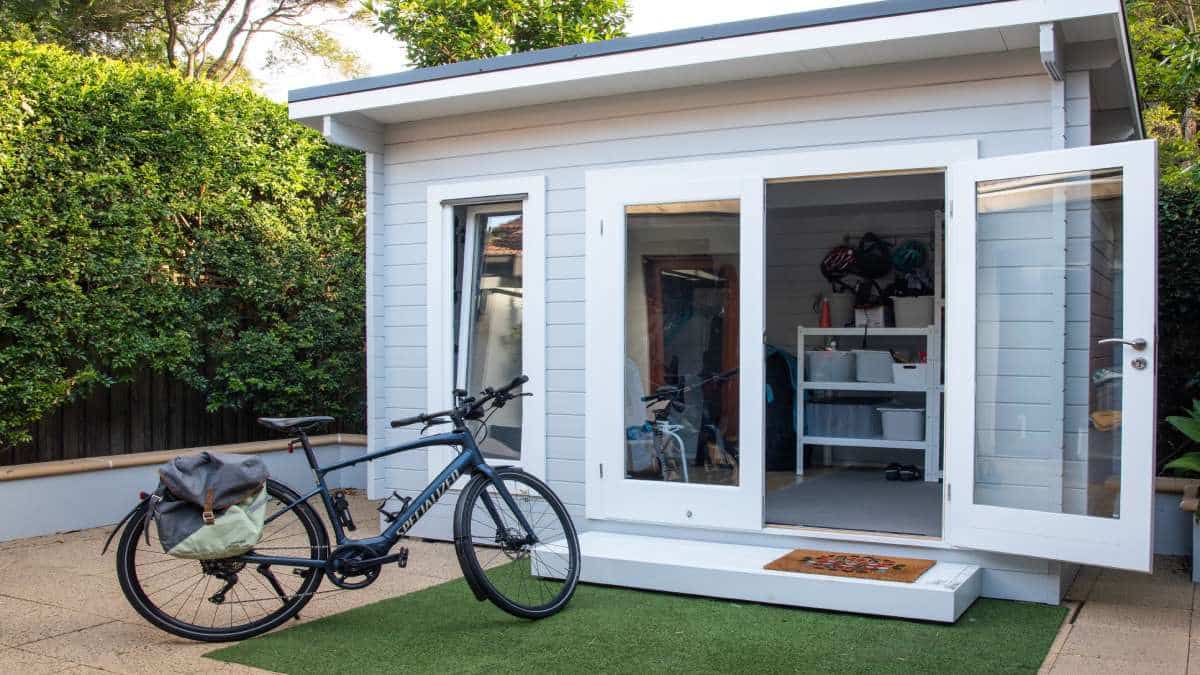 Een kleine, losstaande veranda die je niet zomaar zonder melding of vergunning mag plaatsen. Voor de veranda staat een fiets.