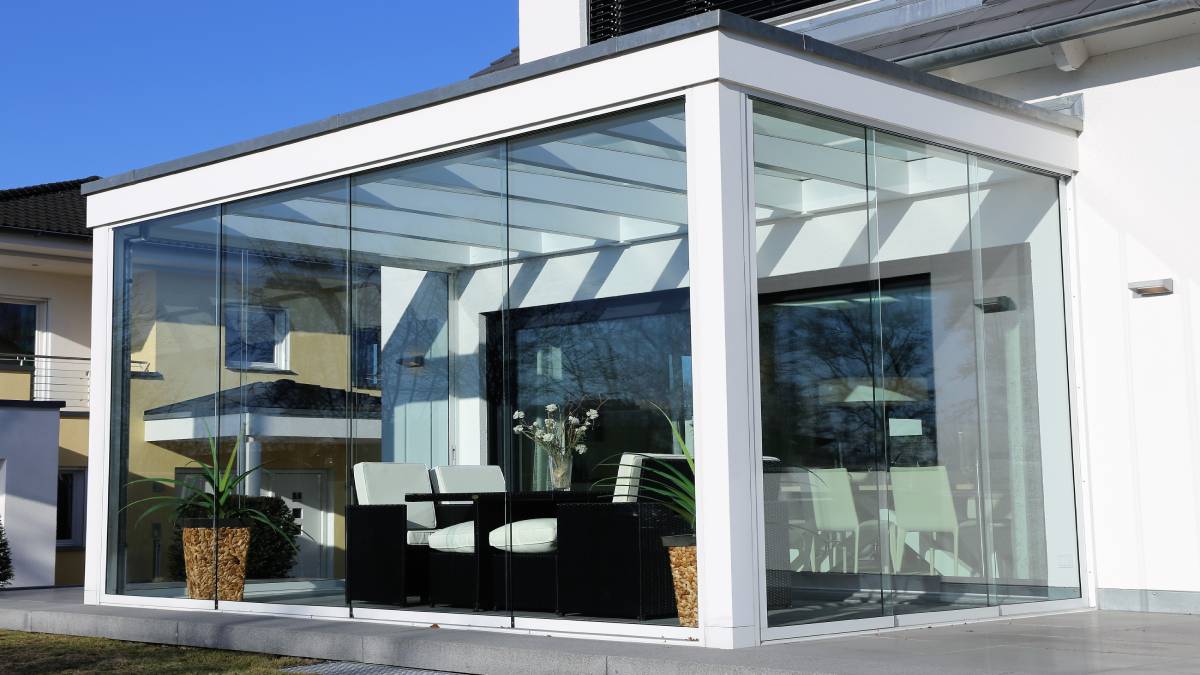 Een moderne aluminium veranda met grote ramen en witte profielen.