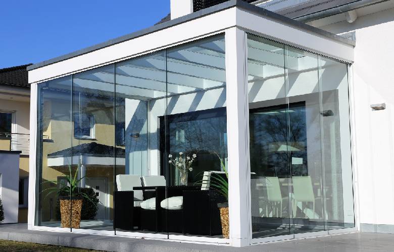 Een moderne aluminium veranda met grote ramen en witte profielen.