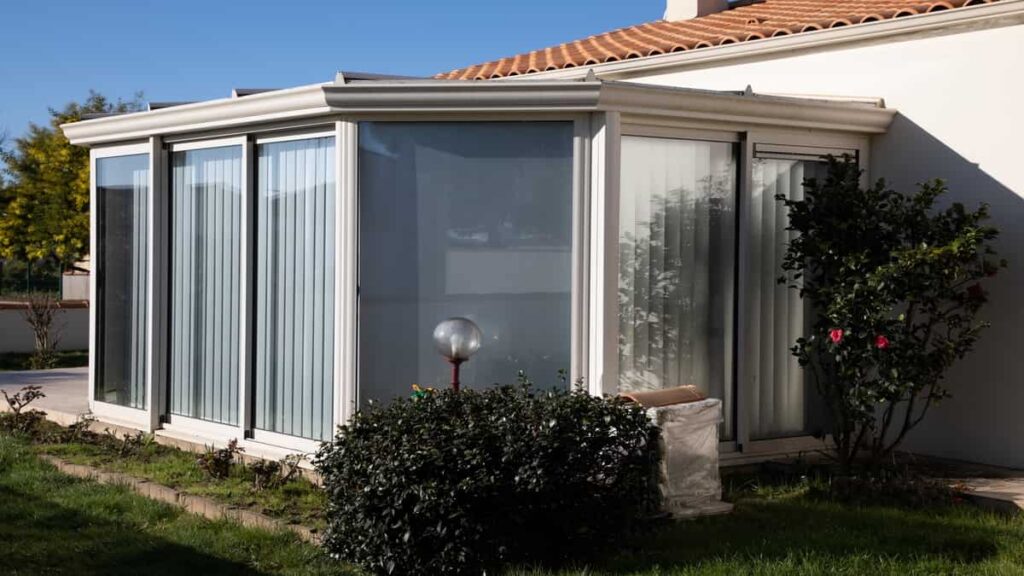Een kleinere aluminium woonveranda met glazen wanden.